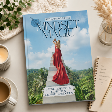 Buchcover "Mindset Magic" mit einer Frau in rotem Kleid auf einer Treppe in einer Landschaft.